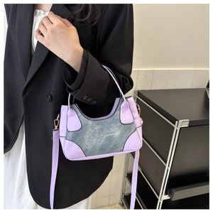 Detail of color-block saddle bag featuring purple PU leather and denim patchwork