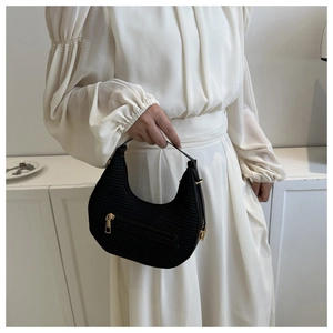 Detail of a black faux crocodile hobo bag with gold hardware and front zipper pocket