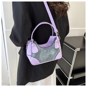 Detail of lavender purple and blue denim contrast stitching underarm bag on model