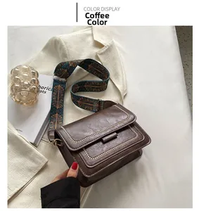 Detail of coffee brown retro crossbody bag with textured leather and wide geometric strap