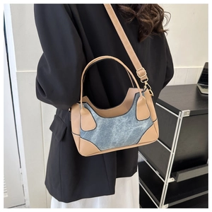 Detail of woman wearing a bicolor leather and denim shoulder bag with adjustable strap