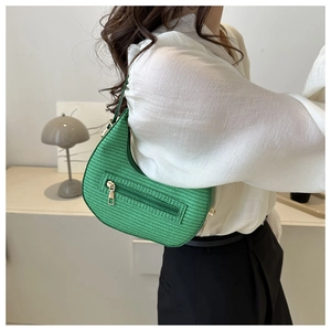 Detail of green woven shoulder bag with front zipper pocket and stylish leather strap