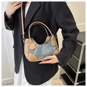 Model wearing a vintage denim and brown leather contrast stitching saddle shoulder bag
