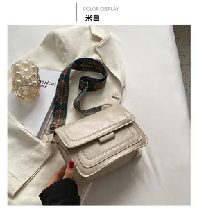 Close-up of off-white minimalist square shoulder bag with ethnic patterned strap details