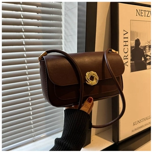 Detail of vintage burgundy leather shoulder bag with decorative gold weave lock