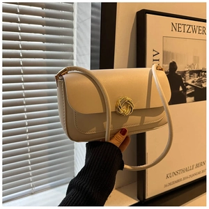Detail of minimalist cream square shoulder bag with elegant golden twist lock buckle