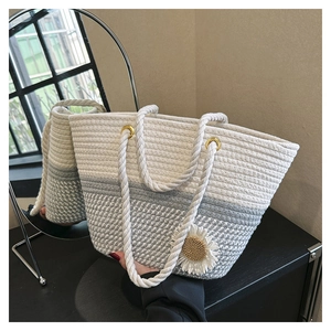 Close-up of woven cotton tote bag with white daisy charm and grey striped texture