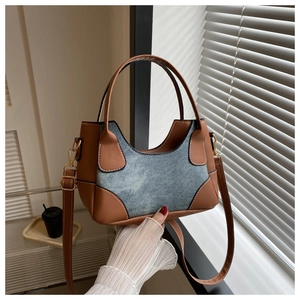 Detail of vintage color-blocking bag with brown leather and blue denim patchwork