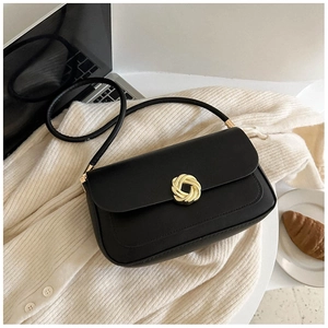Close-up of minimalist black square shoulder bag with vintage gold twist-lock on knit fabric