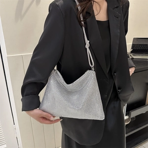 Chic silver rhinestone hobo bag with knotted strap shown on model in black suit