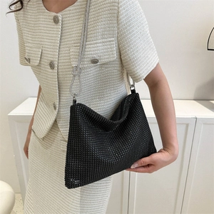 Sparkling black rhinestone baguette bag with silver knotted chain strap worn by model