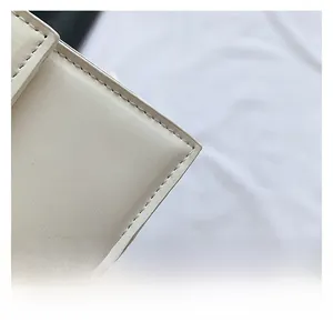 Close-up of cream PU leather texture and precise double stitching on square bag