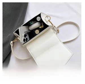 Top view of white PU leather crossbody bag showing inner storage for phone and lipstick