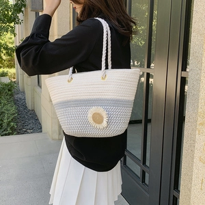 Handwoven summer tote bag with blue gradient colors and a white daisy floral accent