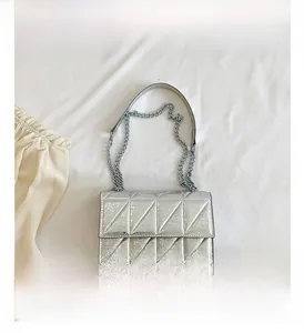 Detailed top view of silver quilted crossbody bag with metallic chain shoulder strap