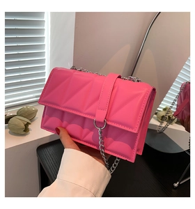 Détail du sac à bandoulière rose matelassé avec chaîne argentée et anneau métallique