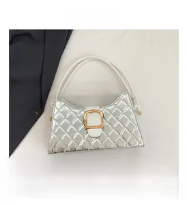 Detailed view of silver quilted leather handbag with white strap and gold square buckle