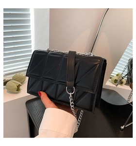 Détail du sac à bandoulière matelassé noir avec chaîne argentée et boucle anneau chic