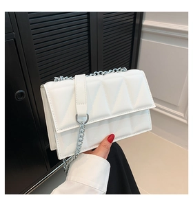 Détail du sac bandoulière blanc matelassé avec chaîne argentée et fermoir à anneau