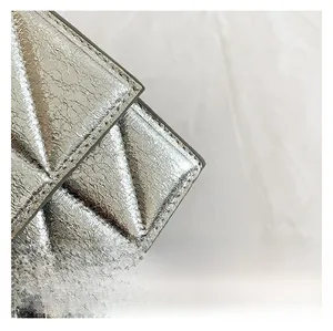 Macro detail of silver quilted faux leather fabric with textured crackle finish