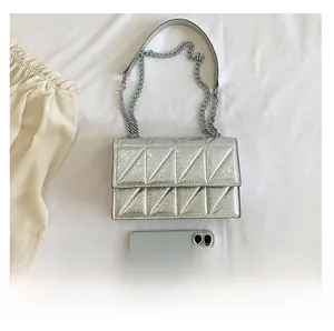 Silver quilted crossbody bag detail showing metallic finish and phone size comparison