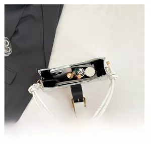 Internal capacity of the white textured baguette bag with lipstick and cosmetics