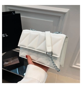 Détail du sac bandoulière blanc matelassé avec surpiqûres et chaîne en argent chic