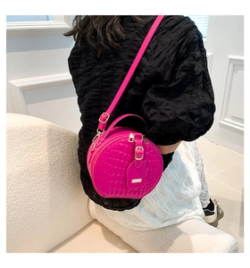 Detailansicht der pinken runden Stepptasche mit goldener Schließe am Schultergurt