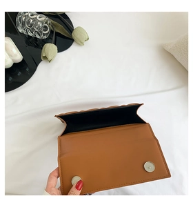 Détail du sac matelassé marron montrant les doubles fermoirs magnétiques et l'intérieur