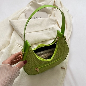 Grass green woven crescent hobo shoulder bag with zipper detail on a white blazer