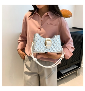Detail view of silver quilted shoulder bag with white woven rope strap and metal buckle