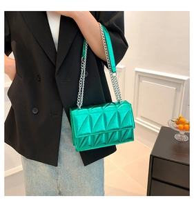 Detail of metallic green crossbody bag with geometric quilting and silver chain strap