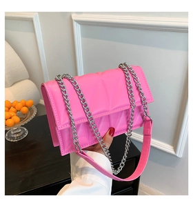 Détail du sac à bandoulière rose vif avec matelassage géométrique et chaîne argent