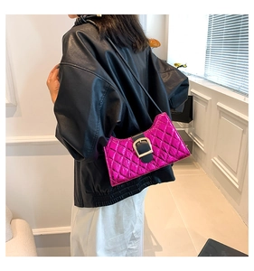 Close-up of fuchsia quilted patent leather shoulder bag with gold square buckle detail