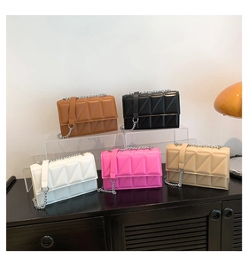Détail de petits sacs bandoulière matelassés en cinq couleurs sur support transparent