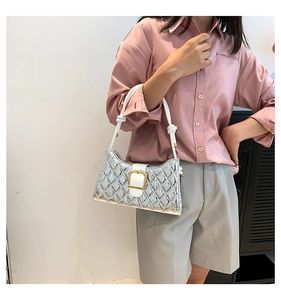 Detail of silver metallic quilted bag with white handle and large gold buckle closure