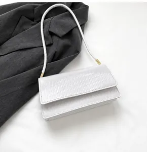 Borsa a tracolla bianca con texture ondulata e smartphone per riferimento dimensionale