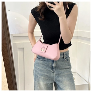 Detailed view of a pink crescent underarm bag featuring a delicate gold circular buckle