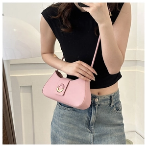 Pink leather underarm bag featuring a metallic gold circular clasp and slim top handle
