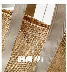 Close-up of hollow woven straw beach bag with cream fabric handles for summer