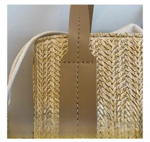 Detail of reinforced stitching on the leather handle and beige woven straw texture