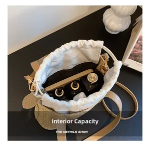 Top view of beige straw bucket bag interior with white canvas drawstring liner and storage