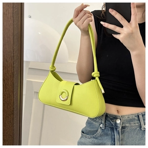 Mirror selfie showing a vibrant neon green faux leather baguette bag with metal buckle