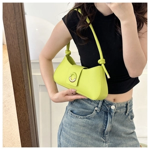 Detail of neon green underarm bag with decorative ring buckle and knotted shoulder strap
