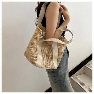 Detail of woven straw texture and cream fabric handles on a beige summer tote bag