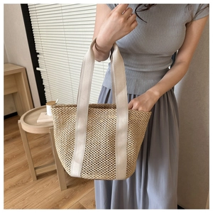 Detail of hollow woven beach tote with wide canvas handles for summer vacation