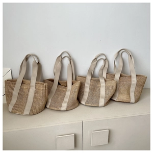 Close-up of four straw woven tote bags with hollow mesh texture and beige canvas handles