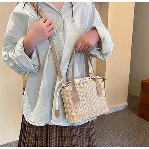 Close-up of handwoven straw bag with synthetic leather straps and drawstring liner