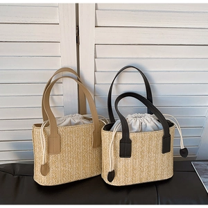 Close-up of woven straw handbag featuring herringbone pattern and drawstring closure