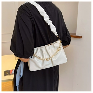 Borsa sottobraccio bianca a pieghe con catena di perle mostrata sul retro di una modella